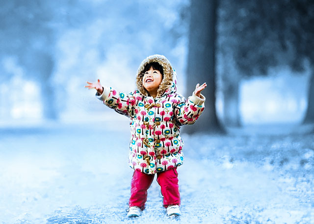 Child with winter coat in park.