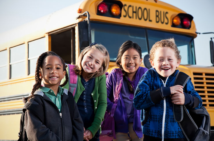 Kids waiting in front of school bus.