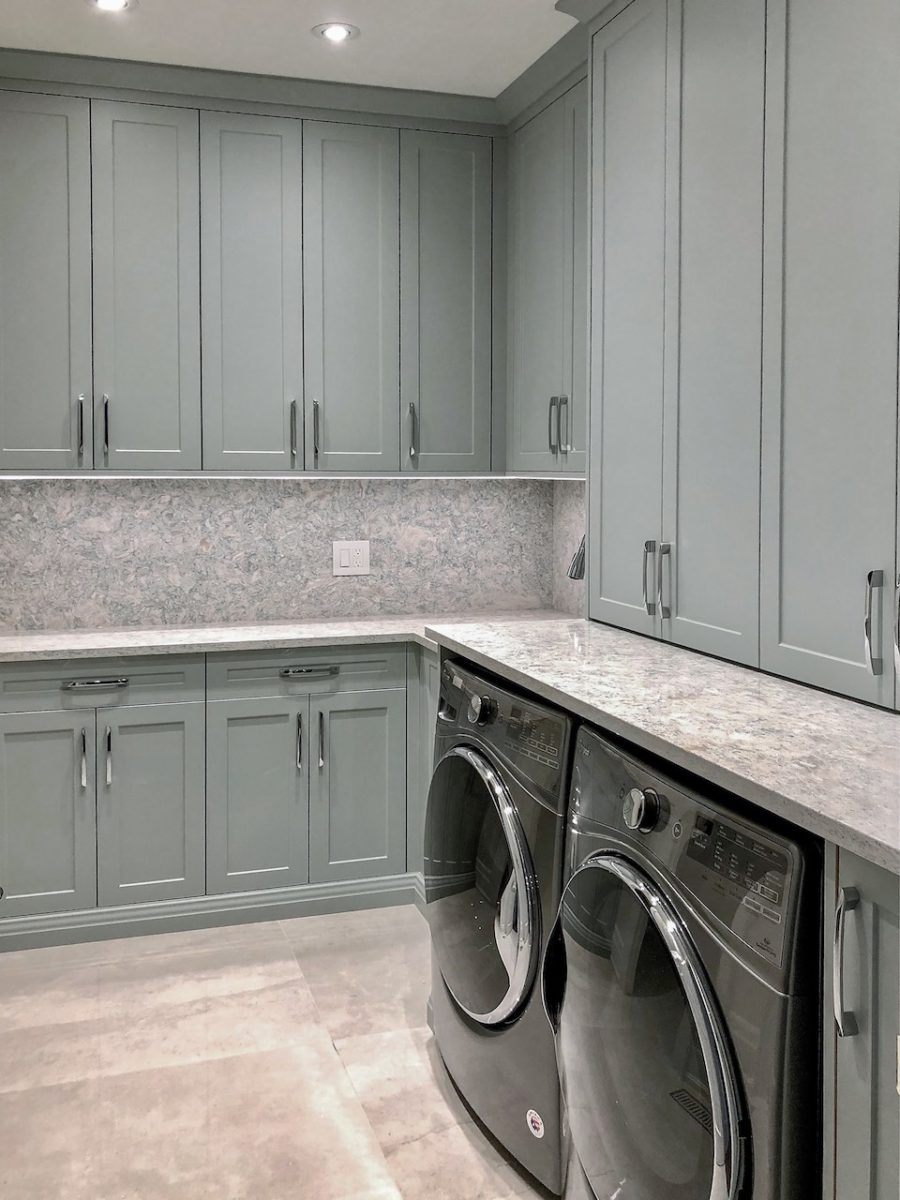 gray laundry room decor with cabinets and appliances