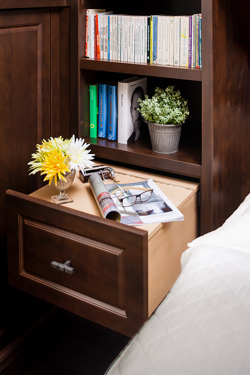 wall bed side table with magazine, glasses, yellow flower